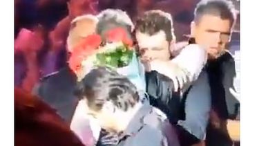 Luego de jalones y empujones, Alejandro se acerca al joven y recibe las flores, mismas que agradece con un caluroso abrazo (Foto: Captura)